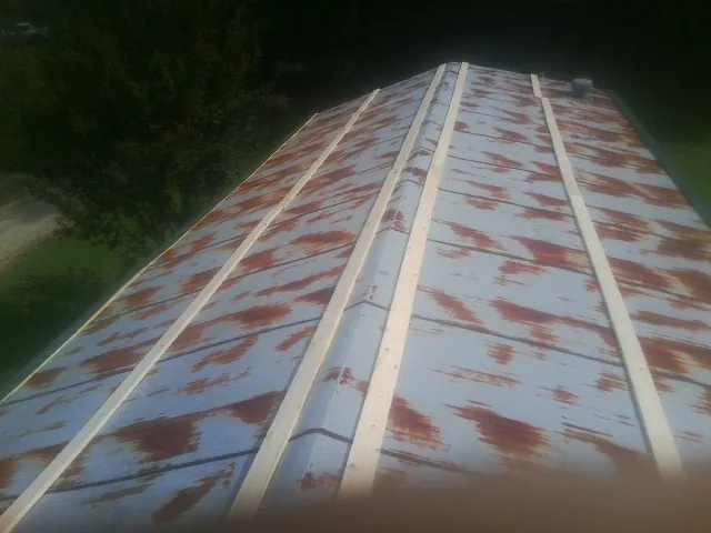 Rusted metal roof panels with new wood purlins before replacement — Storm Damage Roof Repair in Silt by Roofing Brothers