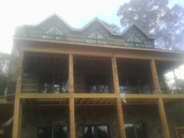 Dormers and porch framing on a large log home under construction — Roof Coating work by our crew in Silt